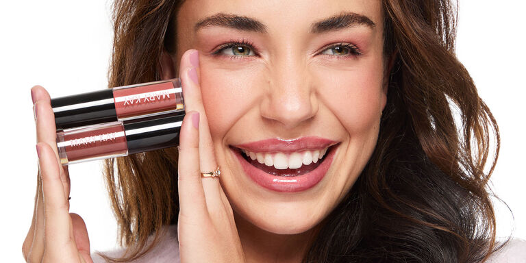Woman smiling and holding Mary Kay Lip Oil